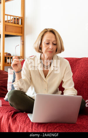 Elegant mature woman using computer at home Stock Photo