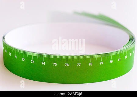 Meter tape for measuring rolled into a roll, on a light background. Selective focus Stock Photo