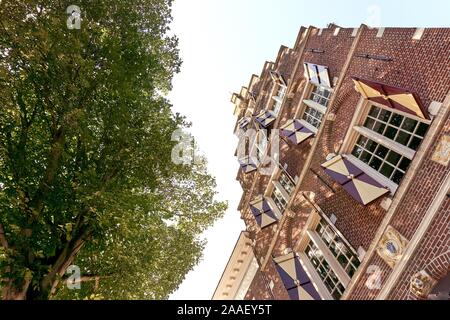 Low view on facade of historic dutch house with window shutters and tree in Harlingen The Netherlands Stock Photo