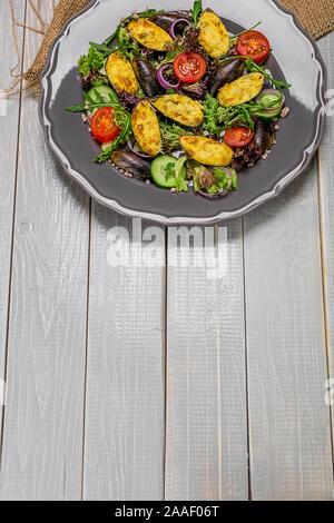 Delicious Seafood salad with vegetables and mussels on wooden table in rustic style Stock Photo