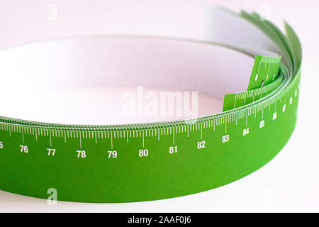 Meter tape for measuring rolled into a roll, on a light background. Selective focus Stock Photo