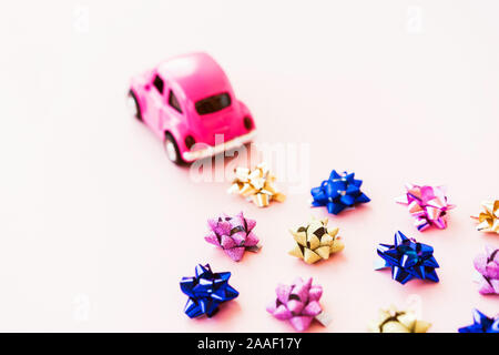 Small toy kids car and multi colored bows for gift wrapping Stock Photo