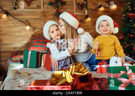 Mother and children with gifts in the house for Christmas Stock Photo