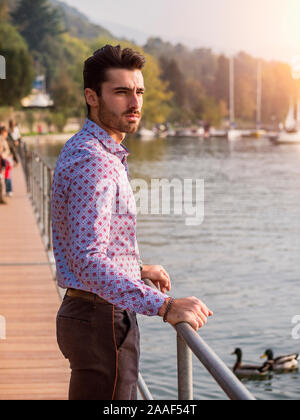 Young man wearing beside picturesque river or lake Stock Photo