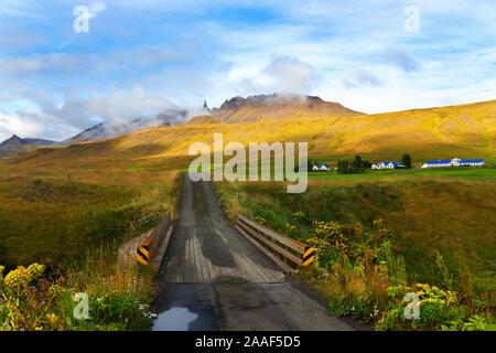 Country road leading big blue roofed farm on the Horga river in Northeastern Iceland Stock Photo