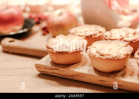 Thanksgiving Fall traditional homemade apple pies on wooden board for autumn holiday dining. Cozy home mood Stock Photo