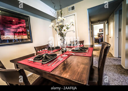 Red placemats complement the artwork in a dining room at Four Seasons apartments in Mobile, Alabama. Stock Photo