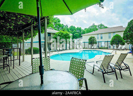 The swimming pool features an outdoor seating area with a covered pergola at Robinwood Apartments in Mobile, Alabama. Stock Photo