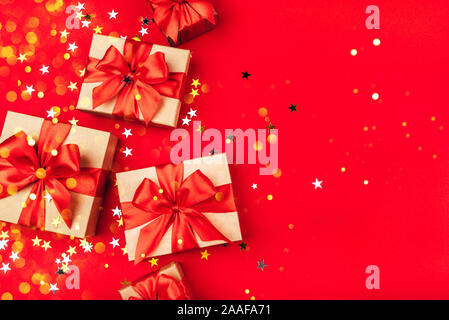 Several gift boxes with bows on a red background. Stock Photo