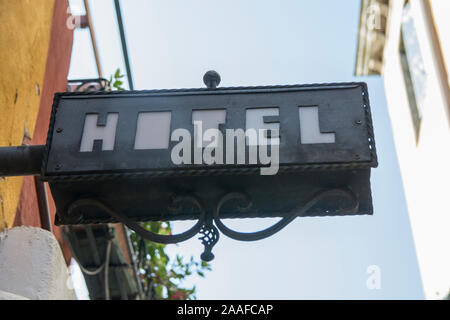 Black 'Hotel' Sign, made of metal, hanging from wall in Venice, Italy Stock Photo