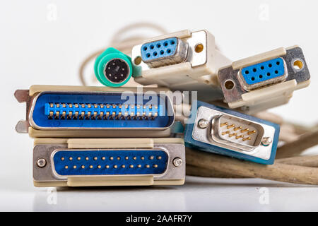 Old computer cables used to connect peripheral devices. Plugs and connectors for old IT applications. Light background. Stock Photo