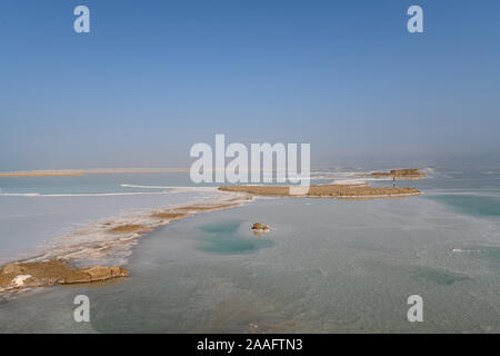 View of Dead Sea coastline with it's beautiful sand and salt in the middle of the water. Aerial shot captured from the shore Stock Photo