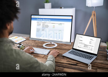 Close-up Of Young Businessman Using Online Banking Service On Laptop In Office Stock Photo
