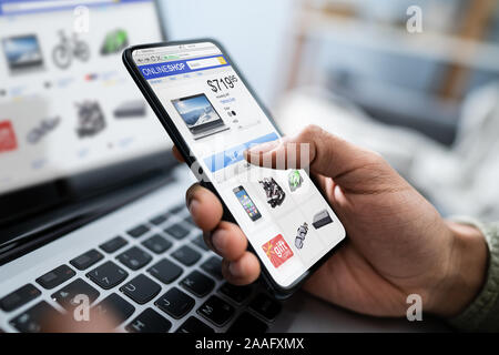 Close-up Of A Businessperson's Hand Doing Online Shopping On Smartphone Stock Photo