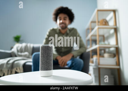 Young Man Using Wireless Speaker At Home Stock Photo