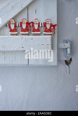 Group of father christmas nicely decorated on a white wooden shutter Stock Photo