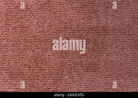 Red artificial carpet texture close-up, top view. Stock Photo