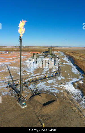 Watford City, North Dakota - Natural gas is flared off at an oil production facility in the Bakken shale formation. Stock Photo
