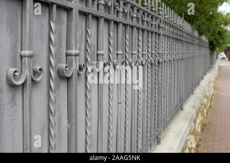 Beautiful decorative cast metal wrought fence with artistic forging. Stock Photo