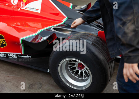 Novosibirsk, Russia - 11.01.2019:  Racing team push Red Ferrari racing sports cars for Formula 1 on the street near to the garage box for pit stop. Stock Photo