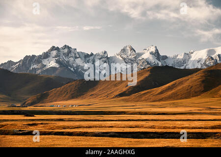 Beautiful scenery of white peaks mountains and yurt camp in the valley near Kel Suu Lake in Naryn region, Kyrgyzstan Stock Photo