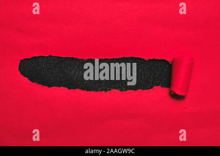 Red torn paper cover with black background. Stock Photo