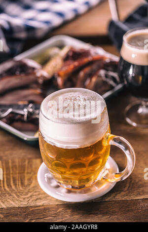 Glass of light beer in pub or restavurant on table with delicoius food. Stock Photo