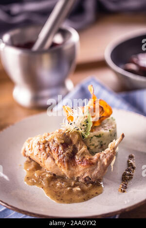 Rabbit leg with mashes potatoes and decoration on plate in restaurant. Stock Photo