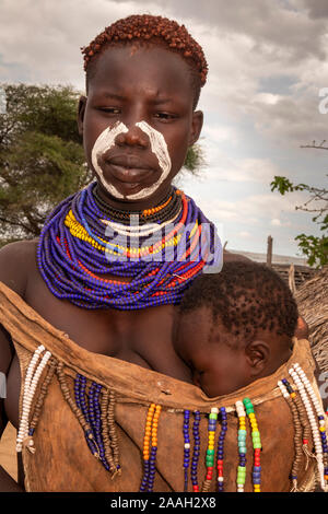 Ethiopia, South Omo, Kolcho village, traditionally dressed and decorated Karo tribal woman with young child Stock Photo