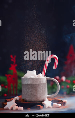 Hot chocolate with star-shaped marshmallow, falling cocoa, and candy cane, winter drink concept Stock Photo