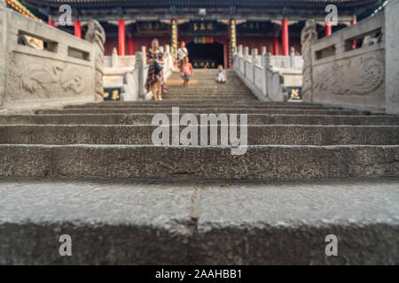 Unidentifiable people walking down the stairs leading to the Buddhist temple at the foot of Huashan mountain, Xian, Shaanxi Province, China Stock Photo