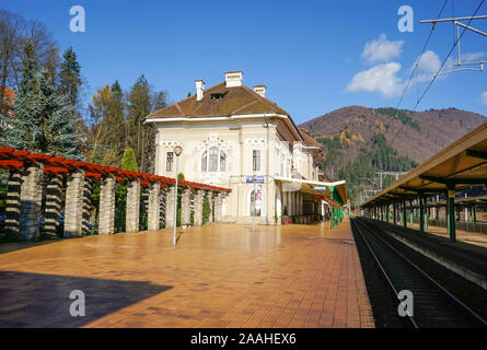 The historic building of the railway station in Sinaia City , Romania , with empty railway and train lines which cross the Carpathian mountains Stock Photo