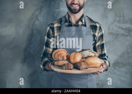 Cropped close up photo of cheerful positive man working as cook serving you ordered bakery food isolated wall concrete grey color background Stock Photo