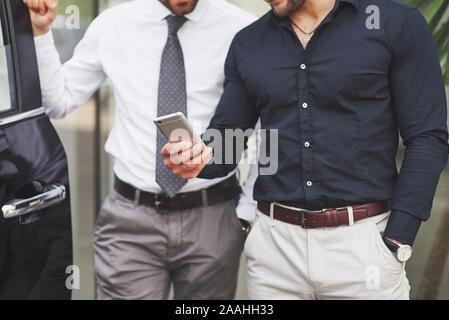 Two happy, confident young businessmen standing by the office Stock Photo