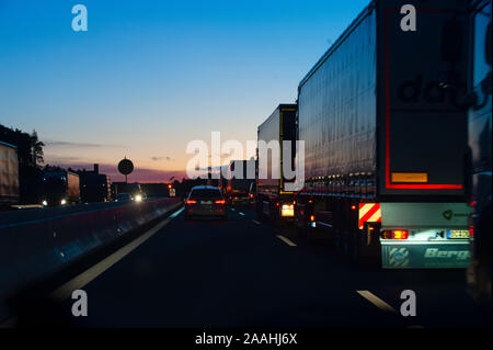 Germany, November 2019. Traffic jam on German road A6. Noisy but nice photo of standing cars and lorries in sunset. Stock Photo