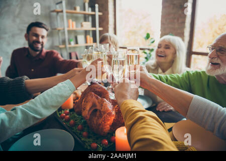 Big happy family sit table enjoy november party thanksgiving celebration have meal candles clink glass with champagne meet relatives small kids Stock Photo