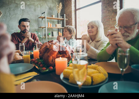 Big family father small little boy retired people gather relatives on event october celebration thanksgiving pray sit table with dinner corns harvest Stock Photo
