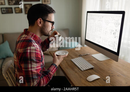 Young handsome designer working on project on computer Stock Photo