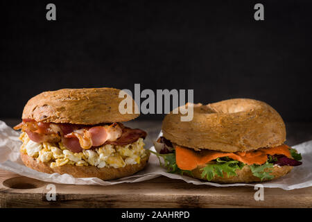 Salmon and bacon bagel sandwiches on wooden table. Stock Photo