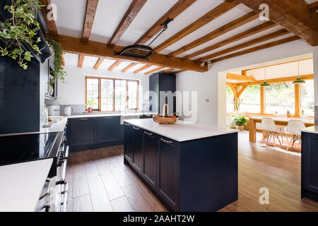 Stylish blue contemporary kitchen diner with oak beams Stock Photo