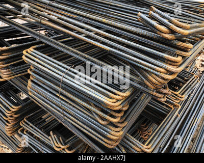 Piled iron reinforcement workpieces. Bent metal parts for reinforcement. Stock Photo
