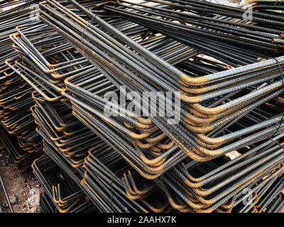 Piled iron reinforcement workpieces. Bent metal parts for reinforcement. Stock Photo