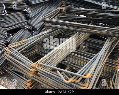 Piled iron reinforcement workpieces. Bent metal parts for reinforcement. Stock Photo