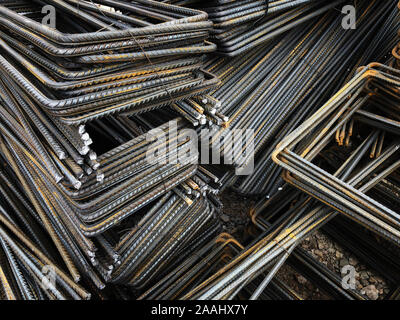 Piled iron reinforcement workpieces. Bent metal parts for reinforcement. Stock Photo