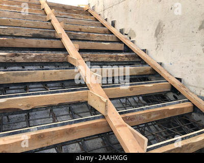 Metal reinforcement and wooden formworks of concrete stairway under construction. Stock Photo