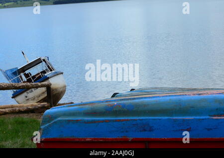 An old boat left on the shore. 'Lom harbour' sign in Bulgarian letters on the boat. Stock Photo