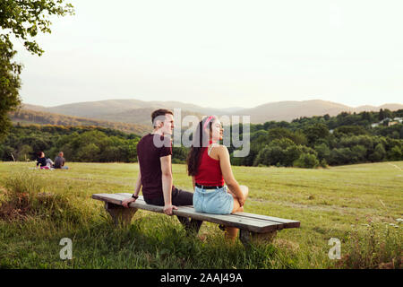 Couple sitting on bench overlooking hills, Wilhelminenberg, Vienna, Austria Stock Photo