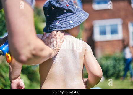 Grandmother putting sun lotion on grandson Stock Photo