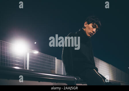 Man leaning against railing waiting, Milan, Italy Stock Photo