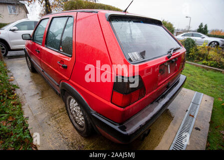 Classic Volkswagen Golf GTI red: Car crash damage and details close up. Crushed metal and plastic. Front bumper damage after a road traffic accident. Stock Photo